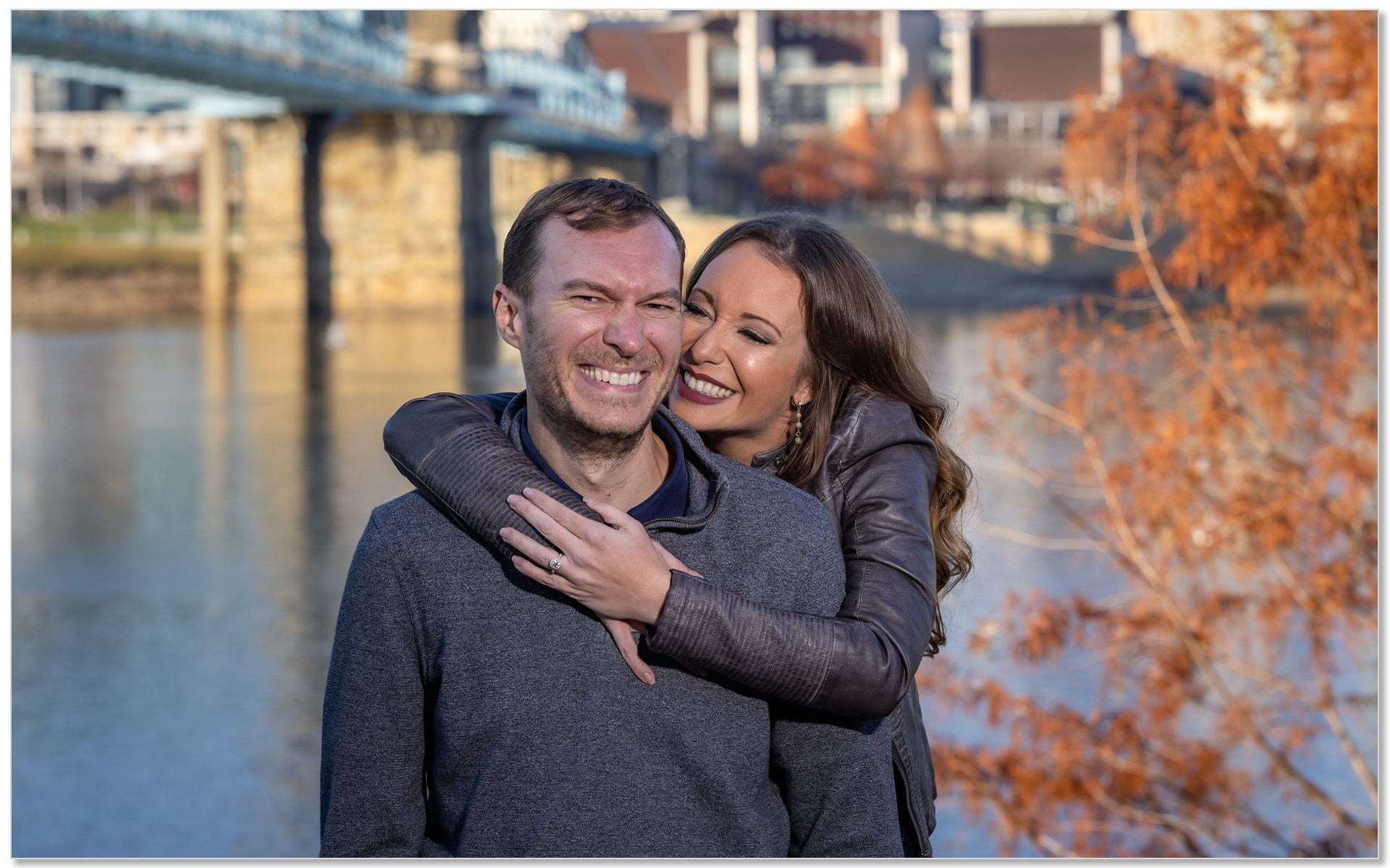 Engagement couple huggin Cincinnati skyline